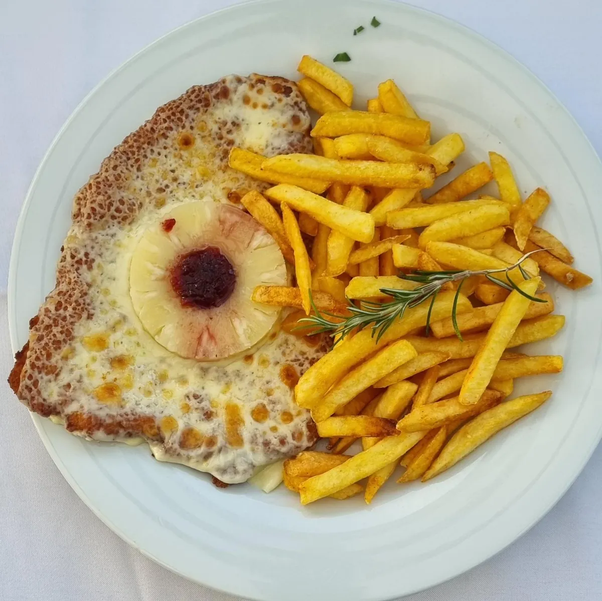 Hawaiian schnitzel with pineapple and melted cheese, served with fries
