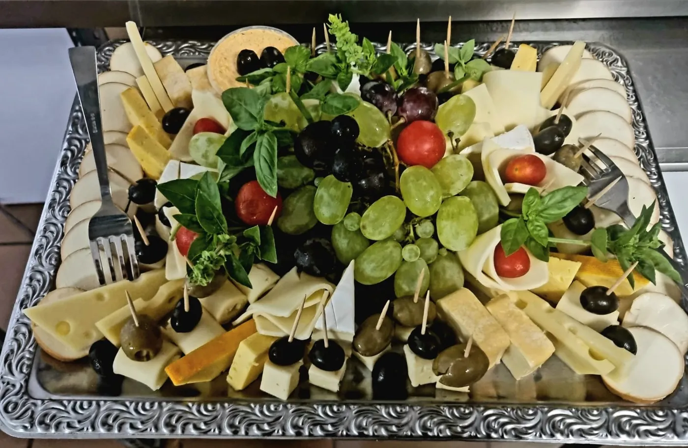 Cheese platter with cheese cubes, grapes, olives and tomatoes