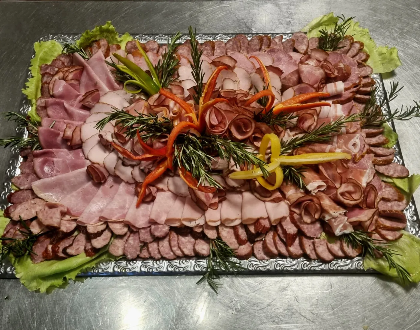 Large platter of cold cuts, decorated with rosemary and peppers